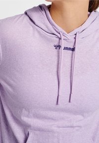 Lila Kapuzenpullover mit strukturierter Oberfläche, ausgestattet mit einer Kordelzugkapuze und einer vorderen Tasche. Markenlogo in Dunkellila auf der Brust aufgedruckt.