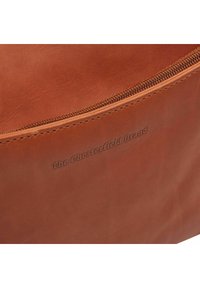 Bolso de cuero marrón con una textura suave, cierre de cremallera y una marca en relieve que dice "The Chesterfield Brand."