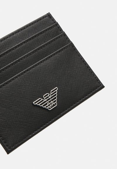 Portafoglio in pelle nera con motivo diagonale, dotato di quattro slot per carte e un accento in logo argentato nell'angolo inferiore.
