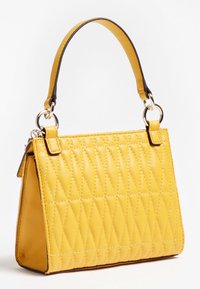 Sac à main matelassé jaune avec une forme structurée, doté d'une base plate, d'une poignée courte, et d'accents métalliques argentés. Texture lisse.