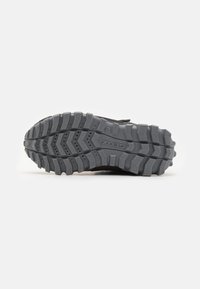 Black athletic shoe sole featuring a rugged grey rubber design with deep treads and traction patterns, suitable for outdoor activities.