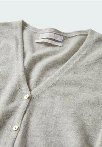 Szary kardigan z dekoltem w serek, wykonany z miękkiej dzianiny, charakteryzujący się teksturowanym wykończeniem i trzema małymi białymi guziczkami z przodu. Obecna metka marki.