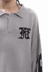 Grijze fleece trui met een kraag, met zwarte geborduurde logo's op de borst en mouw. Losse pasvorm met een zachte textuur.