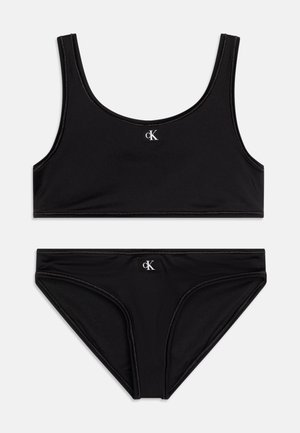 Mustīts mustra musta bikiin komplekt, millel on õlavabadega topp ja madala lõikega aluspüksid, valmistatud siledast materjalist, millel on kerge sära ja logode detailid.