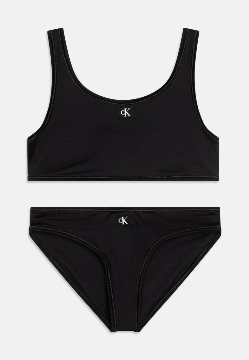 Juodas bikinis, kuriame yra be rankovių viršus ir žemai sėdintys apatiniai, pagamintas iš lygios medžiagos su subtiliu blizgesiu ir logotipo detalėmis.