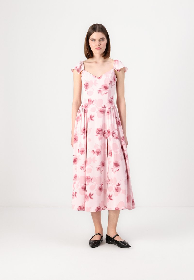 Pink floral midi dress with short ruffled sleeves, V-neckline, and pleated skirt. Worn with black flats featuring decorative hardware.
