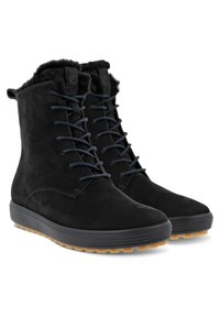 Botas de tobillo de ante negro con un cuello forrado de piel, frente de cordones y una suela de goma duradera con un patrón de agarre texturizado.