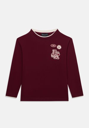 Bordeauxrotes Langarmshirt mit weißem Besatz an der Innenseite des Kragens und Emporio Armani-Patches auf der oberen linken Brust.