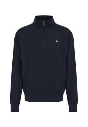 Temno modra majica s četrtinskim zadrgom, pokončnim ovratnikom, rebrastimi manšetami in majhnim emblemom na prsih. Mehka tkanina z gladko teksturo.