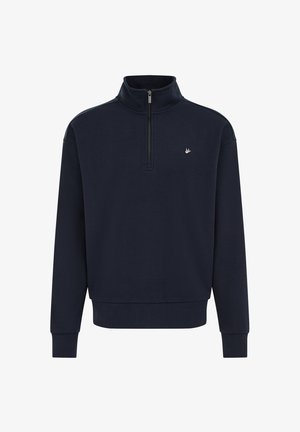 Temno modra majica s četrtinskim zadrgom, pokončnim ovratnikom, rebrastimi manšetami in majhnim emblemom na prsih. Mehka tkanina z gladko teksturo.