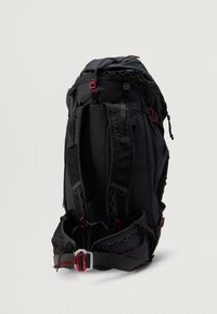 Črn nahrbtnik z rdečimi poudarki, opremljen s podloženimi naramnicami, pasom za boke, zadrgo za zapiranje in teksturirano hrbtno stranjo za podporo.