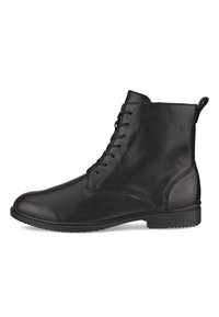 Bota de cuero negro hasta el tobillo con un acabado liso, punta redondeada, parte frontal con cordones y una lengüeta en la parte posterior. Suela de goma para mayor tracción.