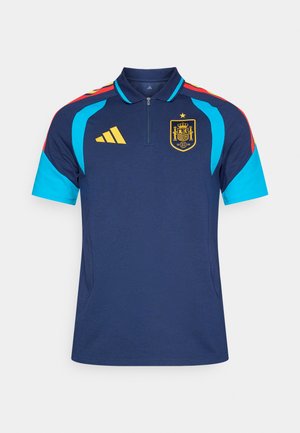 Tumszils sporta polo ar īsām piedurknēm, ar tirkīza akcentiem, sarkani plecu svītrām, rāvējslēdzēja kaklu un dzeltenu emblēmu uz krūtīm.