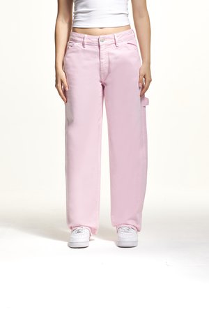 Pantalons cargo roses avec une coupe décontractée, dotés de passants de ceinture, de poches avant et d'une poche latérale. Associés à des baskets blanches.