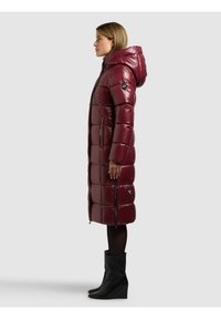 Vínová prošívaná bunda s kapucí, prošívaný vzor, postranní zipy a nášivka s logem. Nositelná s černými vysokými kozačkami na klínu až po kolena.