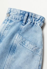 Pantalon en denim bleu clair avec une taille froncée, doté d'une fermeture à bouton en métal et d'une poche arrière unique.