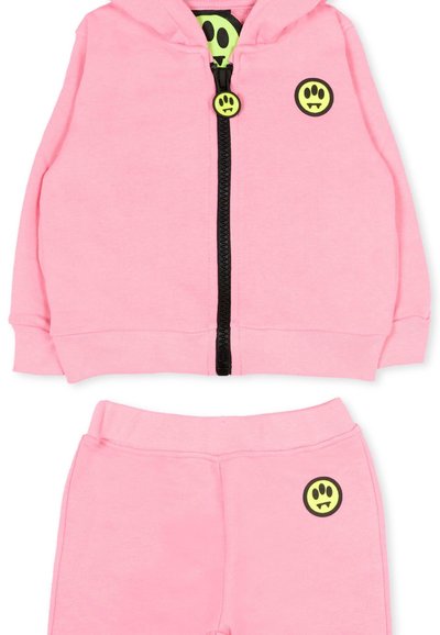 Ensemble pour tout-petit comprenant un sweat à capuche rose et un pantalon avec une fermeture éclair noire et des patchs ronds jaunes ornés d'une empreinte de patte et de crocs.