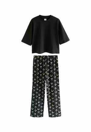 Schwarzes Baumwoll-T-Shirt mit kurzen Ärmeln, kombiniert mit schwarzen Hosen, die weiße Schleifenmuster aufweisen, lockerer Schnitt, elastischer Taillenbund und gerades Bein-Design.