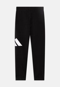 Leggings noirs en matériau extensible, avec un design distinctif à trois rayures blanches sur le côté gauche. Texture lisse, forme ajustée.