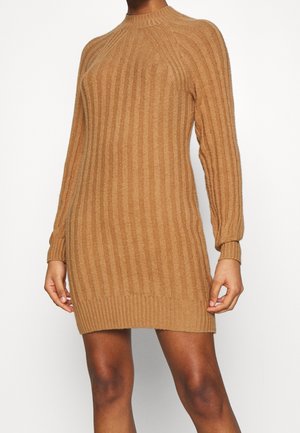 Strickkleid in der Farbe Camel, mit gerippter Textur, langen Ärmeln und hohem Kragen. Figurbetonendes Design mit leicht tailliertem Saum.