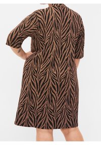 Schwarzes Kleid mit einem strukturierten Blattmuster in metallischem Gold und Bronze. Mit kurzen Ärmeln und einer lockeren, fließenden Form.