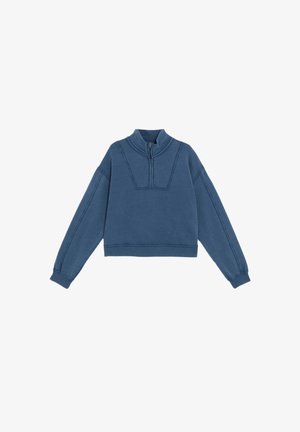 Cropped blue sweatshirt made of soft fabric, featuring a zip collar, dropped shoulders, and decorative stitching along the seams.