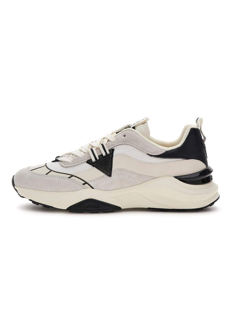 Grijze en witte sneaker met een combinatie van mesh en suède materialen, met een zwarte accent en een dikke witte zool. Triangle-logo aanwezig.