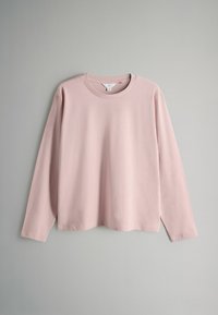 Gari ar garām piedurknēm no mīksta rozā kokvilnas, ar apaļu kakla izgriezumu un brīvu piegriezumu, ar gludu tekstūru un bez redzamām rakstām vai akcentiem.