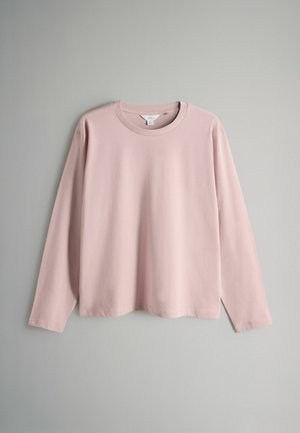 Pitkähihaiseen paita pehmeää vaaleanpunaista puuvillaa, jossa on pyöreä kaula-aukko ja rento istuvuus, sileä pintakuvio ilman näkyviä kuvioita tai tehosteita.