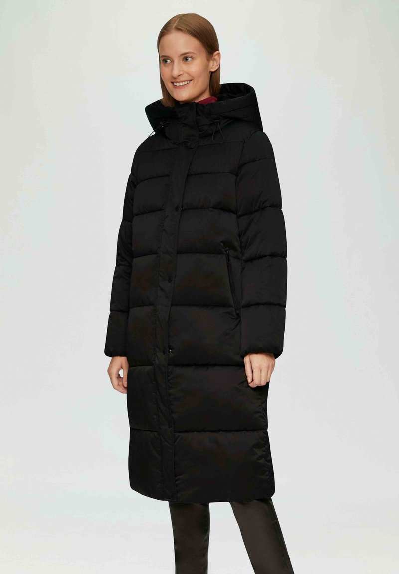 Schwarzer Puffermantel mit langer Silhouette, horizontal gestepptem Design, abnehmbarer Kapuze und Seitentaschen, ausgestattet mit einer glatten Textur und Knopfverschlüssen.
