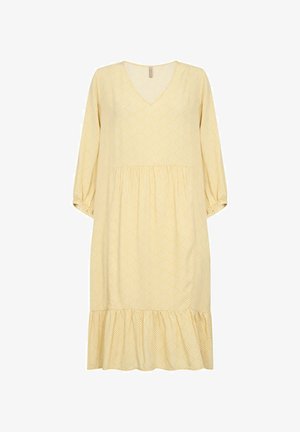 Gelbes Kleid mit V-Ausschnitt, langen Ärmeln und einem gestuften Rüschensaum. Hervorgehoben wird ein geometrisches Muster in einer helleren Farbe. Aus weichem Stoff gefertigt.