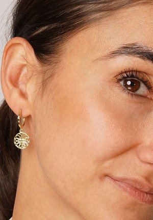 Goldene Creolen mit einem durchbrochenen Blumenmuster. Die Ohrringe hängen an einem kleinen Ring und zeigen kunstvolle Muster sowie eine glänzende Oberfläche.