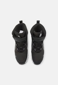 Zwarte high-top sneakers met een synthetisch bovenwerk, gevoerde kraag, vetersluiting en een witte rubberen zool. Beschikt over een Puma-logo aan de zijkant.