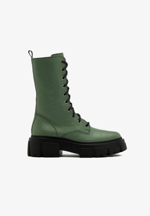 Green leather lace-up knee-high boots with a chunky black sole and textured surface, featuring metal eyelets and a pull tab on the back.