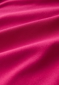 Jasnoróżowy materiał o gładkiej fakturze, z delikatnymi falami i subtelny blaskiem, idealny do różnych zastosowań tekstylnych.