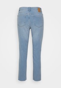 Jeans de denim azul claro com perna reta, cintura média e dois bolsos traseiros. Apresenta um patch de couro castanho na cintura.