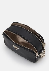 Borsa a tracolla in pelle nera con doppie tasche con zip, dotata di accessori in metallo argentato e superficie testurizzata. L'interno ha un rivestimento neutro.