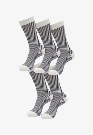 Gestreifte Socken mit einem weißen Bündchen und einer weißen Zehenpartie, die abwechselnd navyblaue und weiße horizontale Streifen aufweisen. Hochwertige Stricktextur.