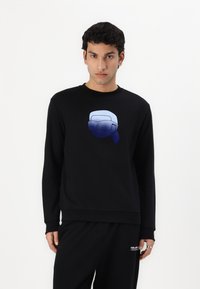 Black sweatshirt featuring a gradient blue graphic of a face in sunglasses at the center. Ribbed cuffs and hem, soft texture.