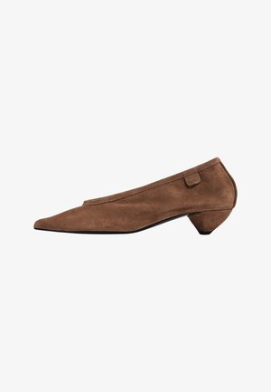 Brauner Veloursleder-Damenschuh mit niedrigem Absatz, spitzer Zehenpartie, geschwungener Ferse und kleinem Stoffetikett nahe dem Knöchel.