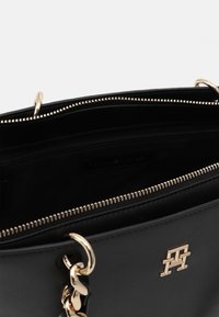 Borsa a tracolla nera in pelle con chiusura con zip, hardware dorato e accento a catena. Presenta una tasca interna e una superficie liscia.