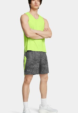 Camisa atlética sin mangas de color verde neón combinada con pantalones cortos grises con estampado. Ambos cuentan con materiales transpirables y un diseño deportivo.