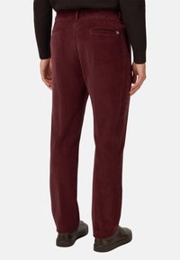 Bordeauxfärgade kordtrosor med en slät textur, utrustade med två bakfickor och subtil branding på höger ficka.