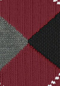 Tissu avec un motif en diamant rouge, gris et noir, présentant une surface en tricot texturée et des accents blancs prononcés le long des bords.