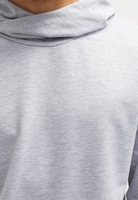 Grauer Hoodie mit weicher Textur, ausgestattet mit einem drapierten Kragen und einer lockeren Passform, hergestellt aus leichtem Stoff.