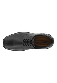 Scarpa di pelle nera con punta quadrata, sei passanti per i lacci e dettagli di cucitura sottili. Interno marrone con marchio.