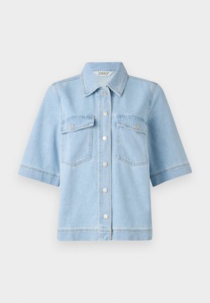 Cămașă din denim de culoare albastru deschis, cu mânecă scurtă, guler în formă de vârf, două buzunare în piept și nasturi cu presiune argintii pe față. Textură curată și netedă.