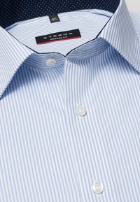 Camicia a righe blu chiaro con una vestibilità moderna. Presenta un colletto classico, bottoni bianchi e una fodera interna del colletto a pois blu navy.