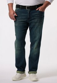 Tmavě modré džíny s rovný střih, mírným vyblednutím a ohrnutým lemem. Kombinované s černým pásem a bílými teniskami.