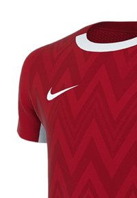 Rotes Sporttrikot mit Zickzackmuster, gefertigt aus atmungsaktivem Material. Verfügt über einen weißen Kragen und das Nike-Logo auf der linken Schulter.